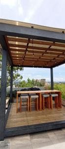 un pabellón con mesas de madera y sillas en una terraza en Hermoso Shanti House en Vista Hermosa 2, en Guatemala