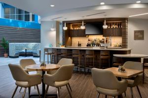 a bar in a restaurant with tables and chairs at EVEN Hotels Waco - University Area, an IHG Hotel in Waco