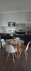 a kitchen with a table and chairs and an oven at Hermoso Shanti House en Vista Hermosa 2 in Guatemala