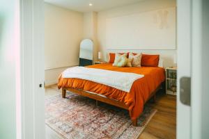 a bedroom with a large bed with an orange blanket at NEW Luxury 1BR Penthouse Apt In Central Halifax in Halifax