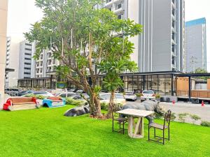 a park with a table and chairs and a tree at O2 Luxury Hotel in Bang Phli