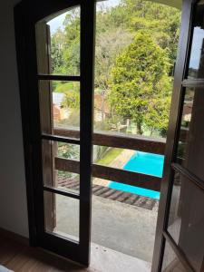 a window with a view of a swimming pool at Pousada Recanto Aurora in Petrópolis