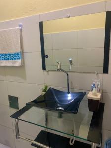 a blue sink in a bathroom with a mirror at Casa próximo da praia in Prado +16 photos