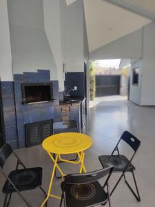 einen gelben Tisch und vier Stühle in einer Küche in der Unterkunft Quarto e piscina in Marechal Cândido Rondon