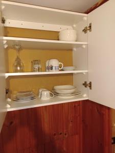 un placard avec des assiettes et de la vaisselle dans l'établissement "Suite Dreams" Descanso Cerca del Mar, à El Quisco