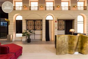 un hall avec banc d'or dans un bâtiment dans l'établissement Scarletz Suites KLCC, Travelet, à Kuala Lumpur