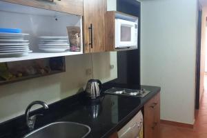 a kitchen with a sink and a microwave at Golf Porto Marina VIP in El Alamein