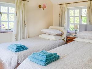 ein Zimmer mit 2 Betten und Handtüchern darauf in der Unterkunft Keepers Cottage Annexe in Edith Weston