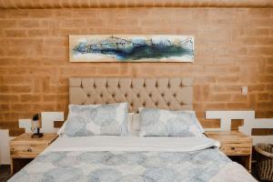 ein Schlafzimmer mit einem Bett mit zwei Gemälden an der Wand in der Unterkunft Chuensuca: naturaleza y bienestar in Villa de Leyva
