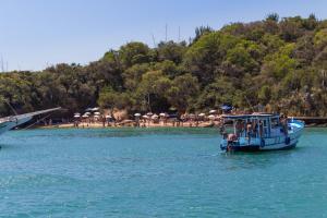 un barco azul en el agua cerca de una playa en Búzios Centro Hotel en Búzios