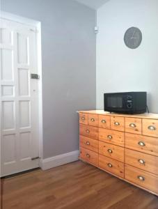 a bedroom with a dresser with a microwave on top of it at Walthamstow 1 bed in London