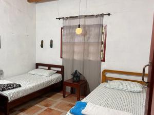 a bedroom with two beds and a table and a window at Galicia, cabaña junto a un bosque y a Cascada in Jardin