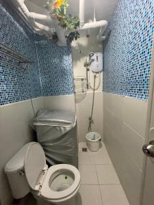 ein kleines Bad mit einem WC und einer Dusche in der Unterkunft Kachada Condotel Urban Deca Home in Manila