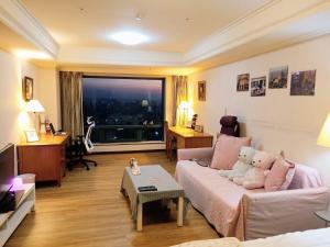 a living room with a teddy bear sitting on a couch at 台中晶華居 Fine House Taichung in Taichung