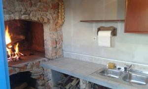 a kitchen with a stone fireplace and a sink at Apartment Skroza in Žirje +14 photos
