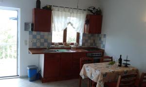 a kitchen with a sink and a table with a table cloth at Apartment Skroza in Žirje