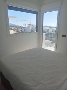 a white bedroom with a bed and a large window at Casa nueva a pie de la Sierra de Guadarrama in Moralzarzal +24 photos