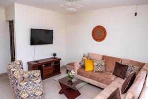 a living room with a couch and a tv at Casa Pinatar en condominio in Santa Cruz de la Sierra