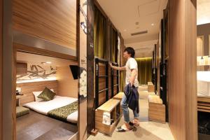 a man is standing in a hotel room at HOTEL Cargo Shinsaibashi in Osaka