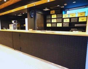 een kassier in een winkel met dozen aan de muur bij Beagle Tokyo Hostel＆Apartments in Tokyo