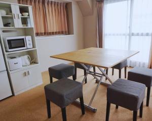 een eetkamer met een tafel en stoelen en een magnetron bij Beagle Tokyo Hostel＆Apartments in Tokyo