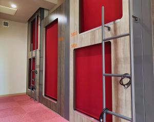una fila di porte rosse in un corridoio di Beagle Tokyo Hostel＆Apartments a Tokyo