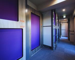 una fila di porte viola in un corridoio di Beagle Tokyo Hostel＆Apartments a Tokyo