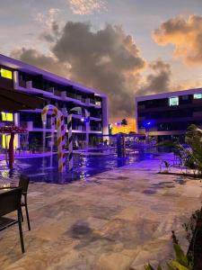 a building with a pool of water in front of a building at Muro Alto - Flat Completo MANA Resort in Porto De Galinhas