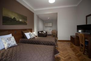 Habitación de hotel con 2 camas y sala de estar. en Ambrosia Suites en Athens