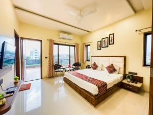 ein Schlafzimmer mit einem großen Bett und einem großen Fenster in der Unterkunft HILLCREST PALACE in Udaipur
