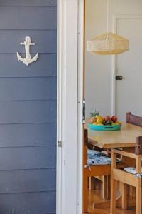 een blauw huis met een tafel en een eetkamer bij Pambula Family Beach House in Pambula Beach