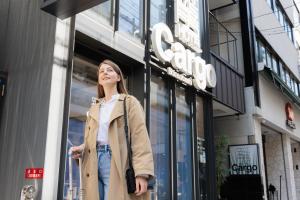 a woman standing in front of a store at HOTEL Cargo Shinsaibashi in Osaka