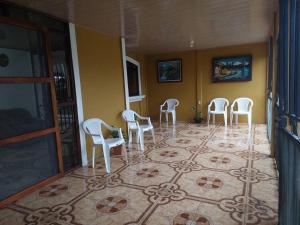 un grupo de sillas blancas sentadas en una habitación en Spacious house, green areas, close to Río Celeste, Toucans House, en Bijagua
