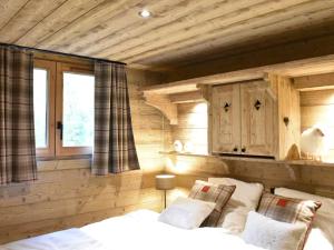 Schlafzimmer mit Holzwänden, einem Bett und einem Fenster in der Unterkunft Appartement 3 pièces à Méribel Village avec WIFI et parking privatif - FR-1-180-600 in Les Allues