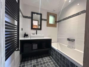 ein Badezimmer mit Waschbecken, Spiegel und Badewanne in der Unterkunft Appartement 3 pièces à Méribel Village avec WIFI et parking privatif - FR-1-180-600 in Les Allues + 21 Fotos