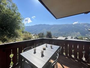 ein Tisch auf einem Balkon mit Blick auf die Berge in der Unterkunft Appartement 3 pièces à Méribel Village avec WIFI et parking privatif - FR-1-180-600 in Les Allues