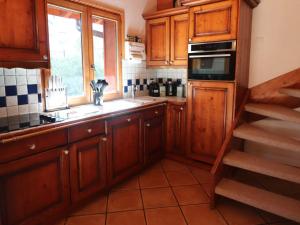 eine Küche mit Holzschränken, einem Waschbecken und einem Fenster in der Unterkunft Appartement Tignes, 5 pièces, 8 personnes - FR-1-502-531 in Tignes