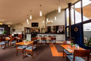Station Motel في باركس: غرفة طعام مع طاولات وكراسي خشبية