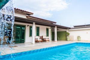 a villa with a swimming pool and a house at casa completa enseada guaruja in Guarujá