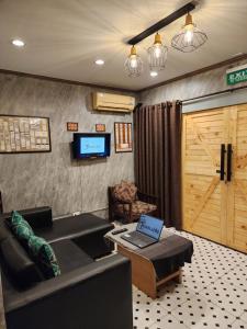 ein Wohnzimmer mit einem Sofa und einem TV in der Unterkunft The Travellers House - Pet Friendly Accommodation in Bangkok