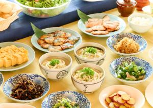 una mesa cubierta con cuencos de diferentes tipos de alimentos en APA Hotel Shinjuku Gyoemmae, en Tokio