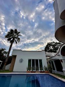 una casa con una piscina y una palmera en Quinta Los Caballos en Ajijic