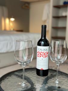 een fles wijn en twee wijnglazen op een tafel bij Quinta Los Caballos in Ajijic