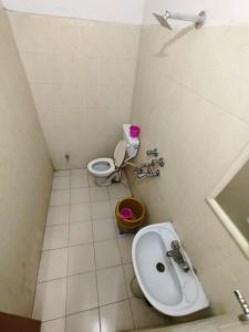 La petite salle de bains est pourvue de toilettes et d'un lavabo. dans l'établissement Hotel Rajgarh, à Jaisalmer