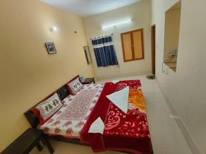 - une petite chambre avec un lit et une couverture rouge dans l'établissement Hotel Rajgarh, à Jaisalmer