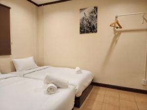 2 Betten in einem Zimmer mit weißer Bettwäsche in der Unterkunft The Travellers House - Pet Friendly Accommodation in Bangkok