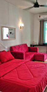 a red bed in a room with a red couch at PD ROOM STAY in Port Dickson