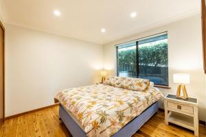 un dormitorio con una cama y una ventana en 41 Leonard Avenue boat parking aircon, en Shoal Bay