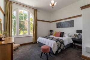 a bedroom with a bed and a window at The Banker's Loft - Central Launceston Art Deco Pad in Launceston