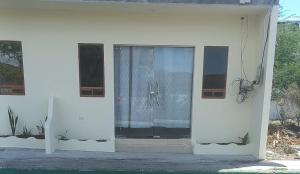 a white house with a window with plants on it at EDIFICIO CUPIL in Puerto Baquerizo Moreno